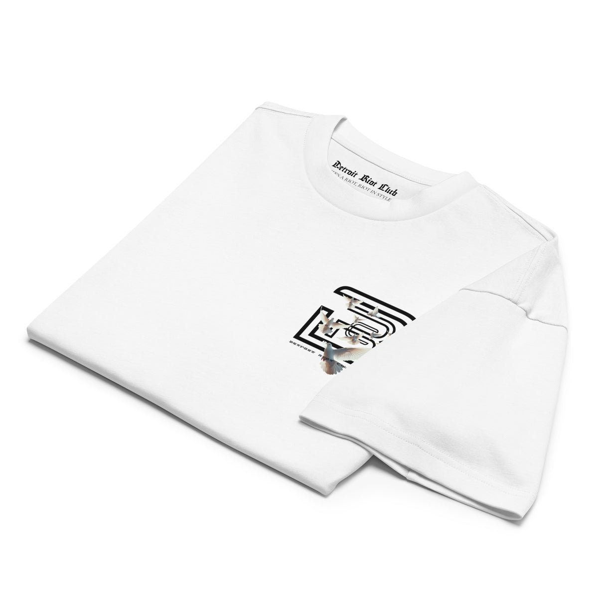 "Folded front flat lay view of the 7oz oversized box-cut tee in dove white, featuring the surrealist dove flight graphic on the upper fold and clean structural edges."