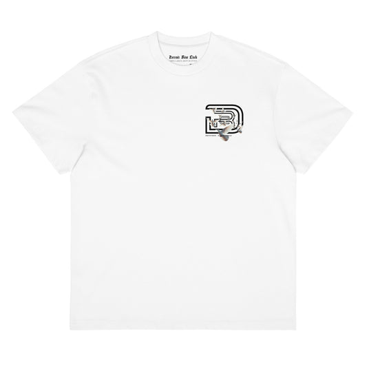 "Front flat lay view of the 7oz oversized box-cut tee in dove white, showcasing the surrealist dove flight graphic on the left chest and clean structural layout."