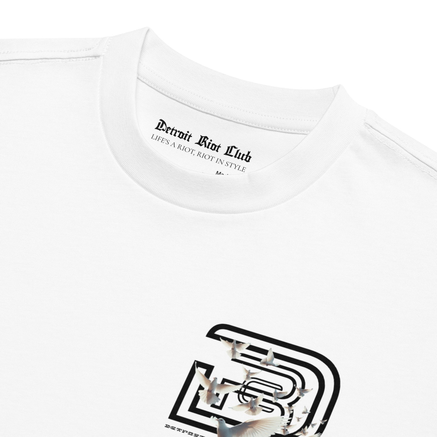 "Close-up of the inner collar branding label and upper chest graphic on the 7oz oversized box-cut tee in dove white."