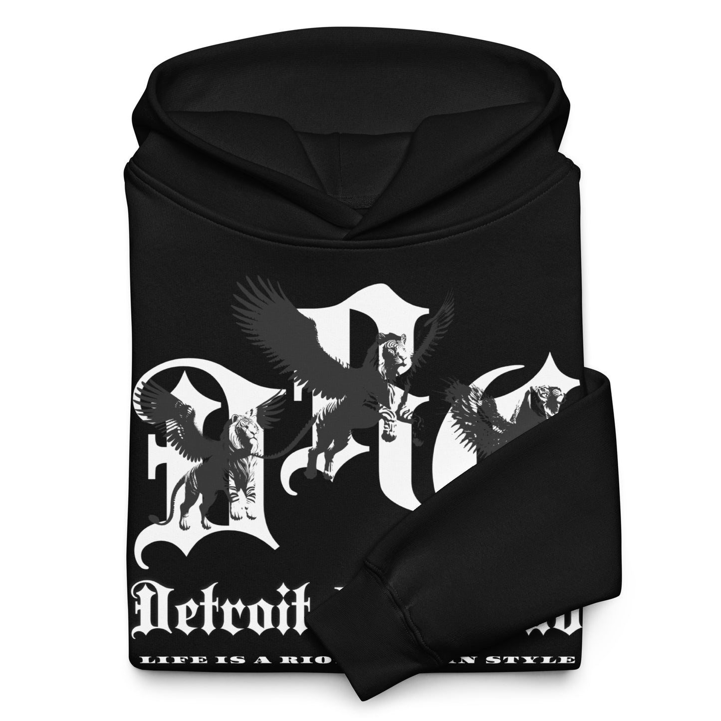 "Close-up detail of the Legacy Crest archival branding neatly folded with one sleeve flipped over the front design. Showcases the 'Strength Through Quality Garments' commitment and crisp white ink on Void Black hardware."