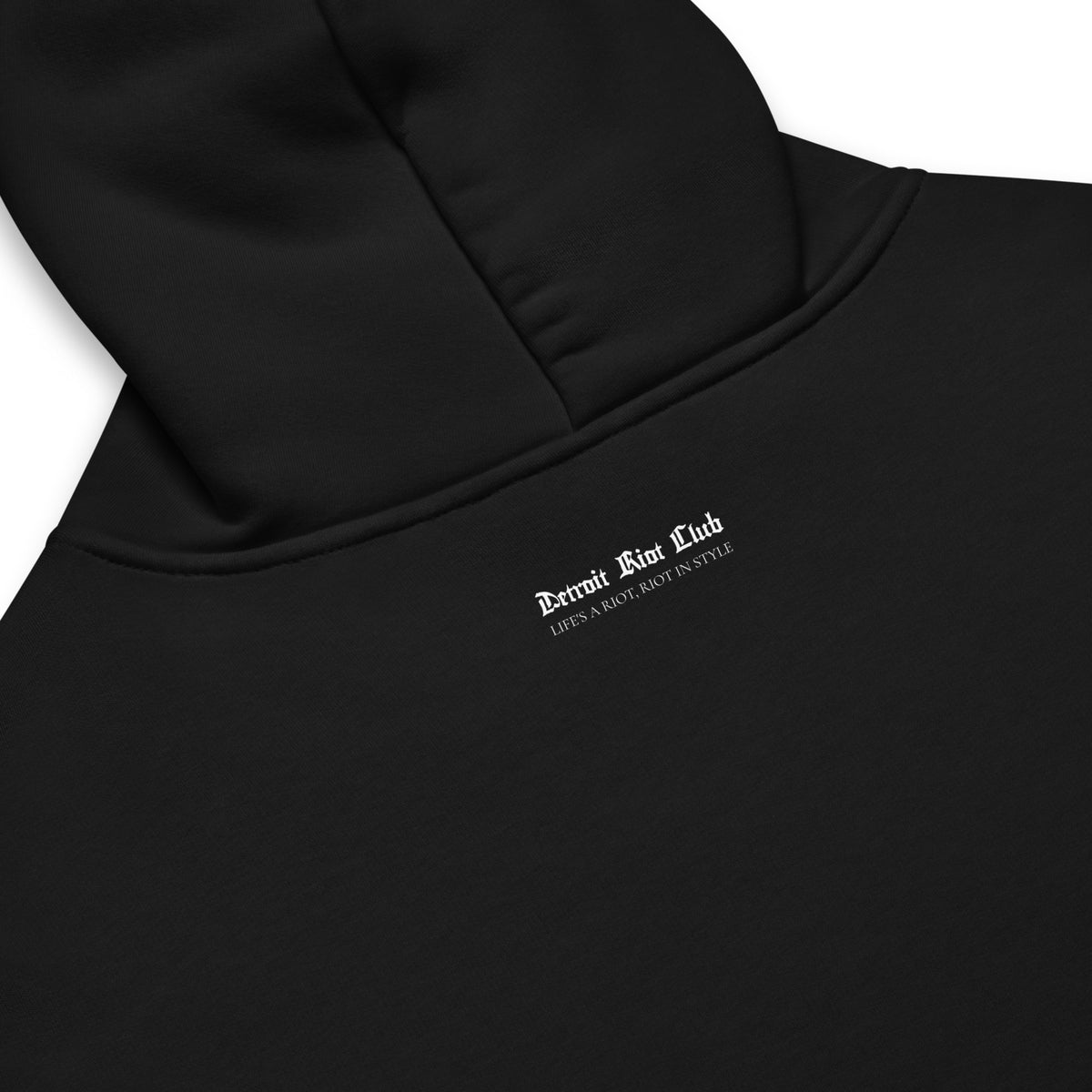 Close-up rear ghost mockup of the Detroit Riot Club Legacy Crest Hoodie in Void Black, focusing on the detailed white Old English crest graphic and brand typography.
