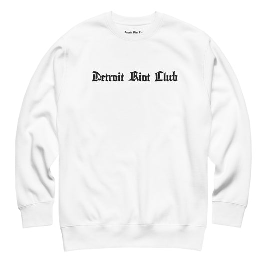 "Front flat lay of the 8.5oz heavyweight crewneck in optic white with natural texture, highlighting the central embroidered gothic brand name logo."