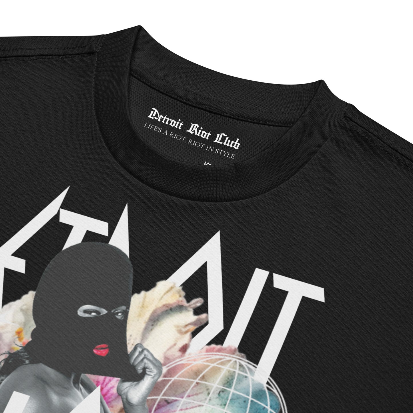 Masked Reality Box Tee – Void Black – Close-up of the upper chest showing the surrealist front graphic and Detroit Riot Club inner neck label